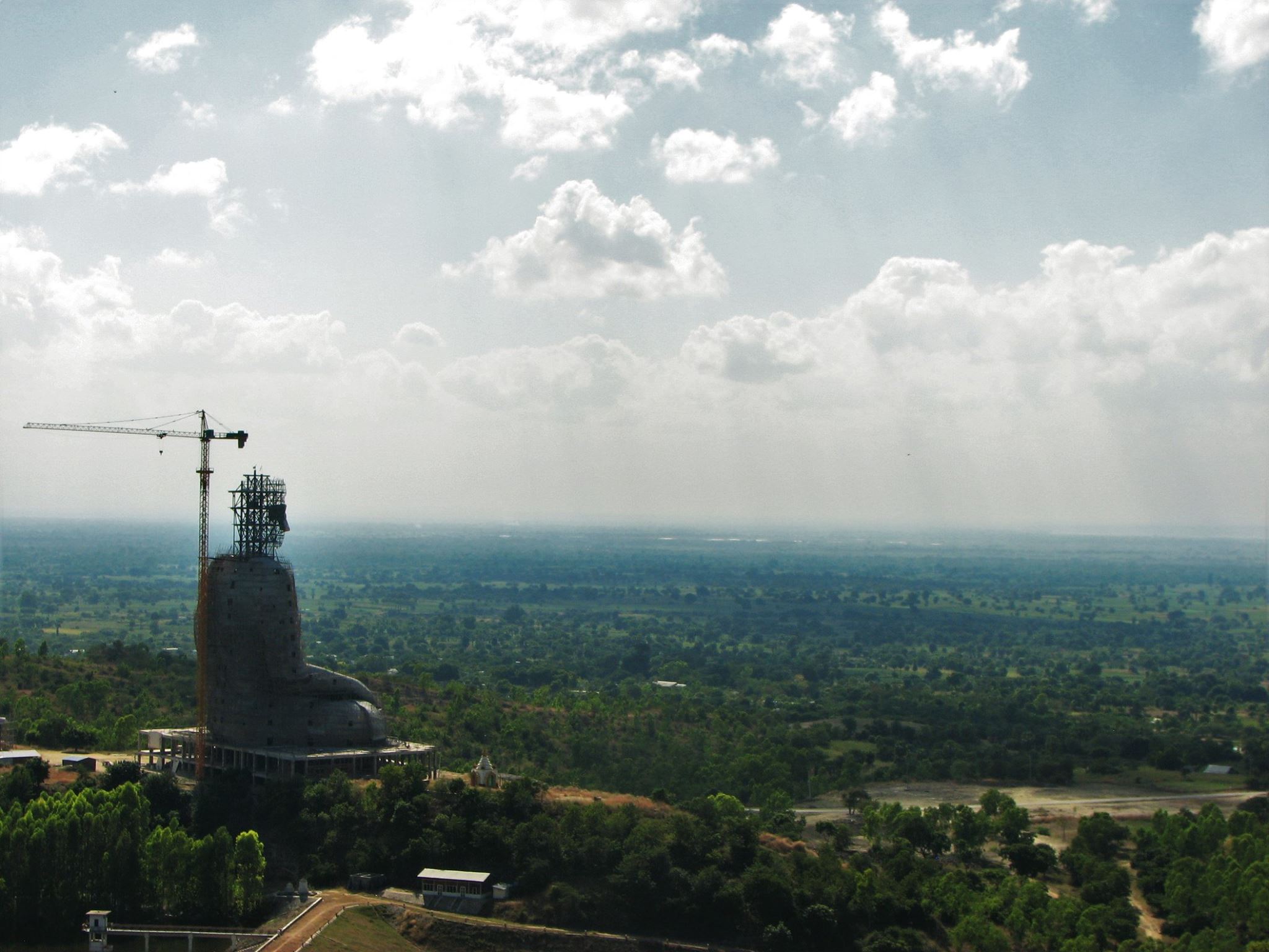 An unfinished statue of the Buddha looms over the Myanmar countryside.